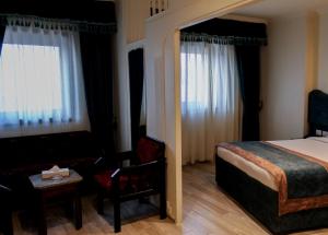 فندق حور محب  في القاهرة: غرفة في الفندق بسرير وكرسي وأريكة