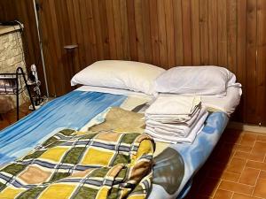 a bed with a blanket and pillows on it at Casa San Rocco in Roccaraso