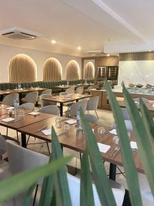 a dining room with wooden tables and chairs at Hôtel Ivotel Abidjan in Abidjan