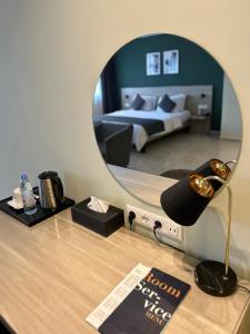 a room with a bed and a mirror on a desk at Hôtel Ivotel Abidjan in Abidjan