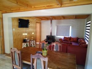 a living room with a table and a couch at Cabaña los sauces in Chile Chico