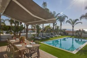 un patio con mesa y sillas junto a una piscina en Sunrise Villa 9, en Ayia Napa