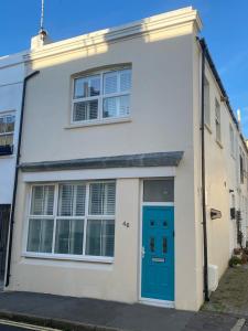 a white house with a blue door on a street at Beautiful Brighton Home in Brighton & Hove