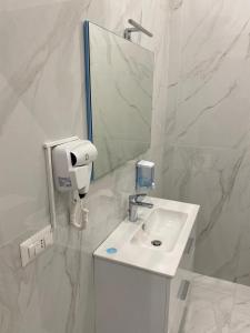 een witte badkamer met een wastafel en een spiegel bij B&B Kemare Suites in Barletta
