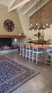 a kitchen with a clock and a table and chairs at Hartland Country House Oudtshoorn in Oudtshoorn