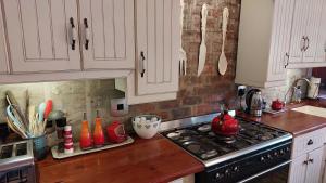 a kitchen with white cabinets and a stove top oven at Hartland Country House Oudtshoorn in Oudtshoorn