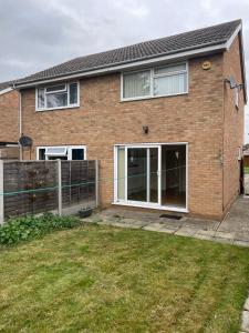 a brick house with sliding doors and a fence at Ashvale, Cambridge in Chesterton