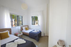1 dormitorio con 2 camas y 2 ventanas en Sunrise Villa 9, en Ayia Napa