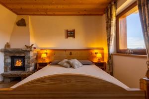 a bedroom with a bed and a fireplace at Le Coin des Mélèzes - NATURE & TREK in Brusson