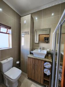 a bathroom with a toilet and a sink at Villa Marche in Van Riebeekhoogte