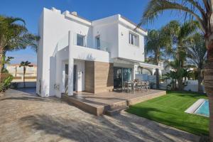 a white house with a patio and a swimming pool at Sunrise Villa 9 in Ayia Napa