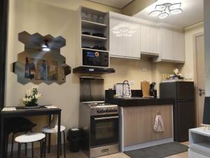 a kitchen with white cabinets and a stove at C516 Place at SMDC Cheer Residences by Lee Portum in Marilao