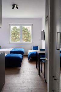 Cette chambre comprend 2 lits, une table et une fenêtre. dans l'établissement Top Loft Znana, à Varsovie