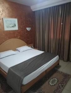 ein Schlafzimmer mit einem Bett in einem Zimmer in der Unterkunft Hotel yasmine in Sfax