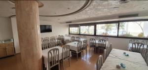 a room with tables and chairs in a restaurant at Hotel yasmine in Sfax