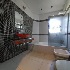 łazienka z wanną, umywalką i toaletą w obiekcie Bagu ÑAMANDU GUAZU w mieście Puerto Iguazú