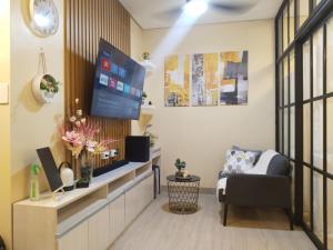 a living room with a flat screen tv and a chair at C516 Place at SMDC Cheer Residences by Lee Portum in Marilao