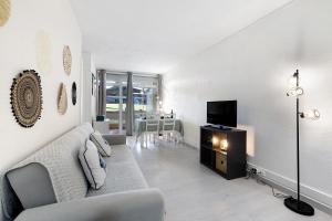 a living room with a couch and a tv at Tróia Beach House in Carvalhal