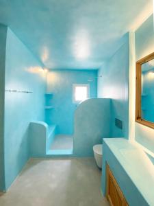 La salle de bains bleue est pourvue de toilettes et d'un lavabo. dans l'établissement Villas Scirocco, à Fira