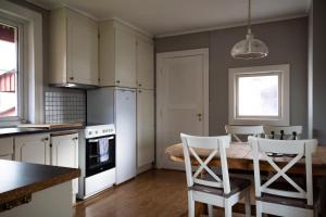 a kitchen with a table and chairs in a kitchen at Osloveien 6 in Røros