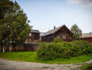 an old house in a yard next to a fence at Osloveien 6 in Røros
