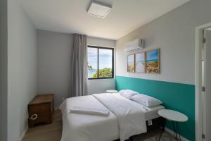 Schlafzimmer mit einem Bett und einem Fenster in der Unterkunft Sossego frente mar com vista para a ilha CCA201 in Florianópolis