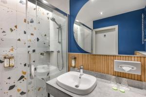 een badkamer met een wastafel en een douche bij Danubius Hotel Annabella in Balatonfüred