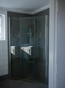 a bathroom with a glass shower with two sinks at Osloveien 6 in Røros