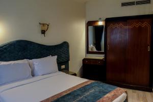 a bedroom with a bed and a dresser and a mirror at Hor Moheb Hotel in Cairo
