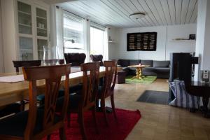 a dining room and living room with a table and chairs at Osloveien 6 in Røros