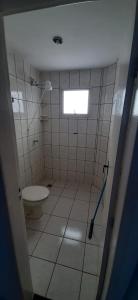 a bathroom with a toilet and a window at Pousada Ikaro in Guarapari