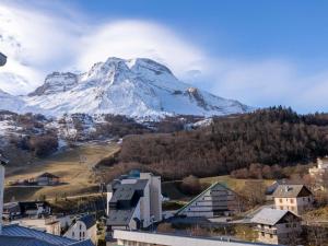 a snow covered mountain in front of a city at Appartement 4 pers cosy avec wifi et casier à skis, Vue pistes, Gourette - FR-1-400-123 in Eaux-Bonnes +2 photos