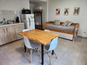 cocina con mesa de madera, sillas y cama en Casa de Campo Flor Dorada en Centenario