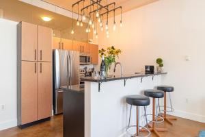 a kitchen with a counter and bar stools at Modern Heritage Studio With Murphy Bed in Victoria