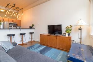 a living room with a couch and a flat screen tv at Modern Heritage Studio With Murphy Bed in Victoria