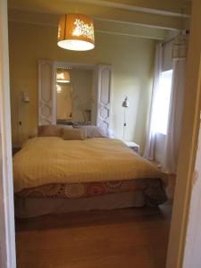 1 dormitorio con 1 cama grande y espejo en L'ENVOLEE, en Champdeniers