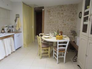 cocina con mesa y sillas en una habitación en L'ENVOLEE, en Champdeniers