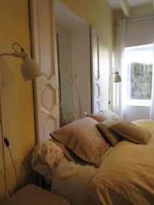 1 dormitorio con cama con almohadas y ventana en L'ENVOLEE, en Champdeniers