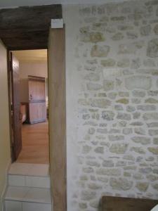 Habitación con pared de piedra y pasillo. en L'ENVOLEE, en Champdeniers
