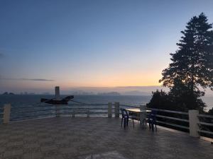 a table and chairs next to the ocean with a kite at Esmeralda View Resort - SHA Extra Plus in Ko Yao Yai