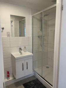 a bathroom with a shower and a sink and a mirror at Modern The Mews Apartment in Bury Saint Edmunds