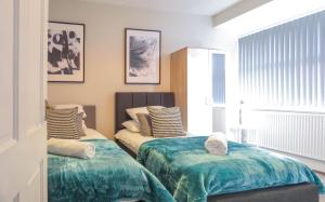 a bedroom with two beds and a window at Tudors eSuites Central Five Bedroom House in Birmingham