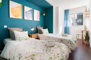 twee bedden in een kamer met blauwe muren bij Restful Minimalist Flat - Balcony in Porto