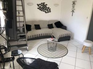 sala de estar con sofá y mesa en Maison Caraïbes en Le Barcarès