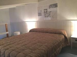 1 dormitorio con 1 cama con manta marrón en Maison Caraïbes en Le Barcarès