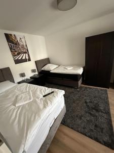 a bedroom with two beds and a rug at bee Apartment 10 Betten für Gruppen & Monteure PS5 in Fellingshausen