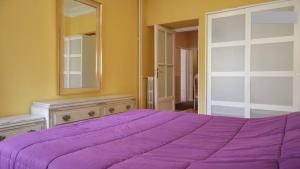 a bedroom with a purple bed and a mirror at Madrid Business El Viso in Madrid