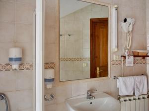 uma casa de banho com um lavatório e um espelho em Hostal Remoña em Espinama