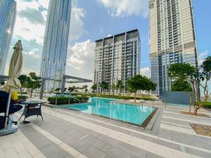 a pool in the middle of a city with tall buildings at CitiHome-2BR creek harbour island in Dubai