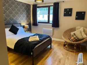 a bedroom with a bed and a chair and a window at Ben Arthur's Bothy Luxury Flat in Arrochar